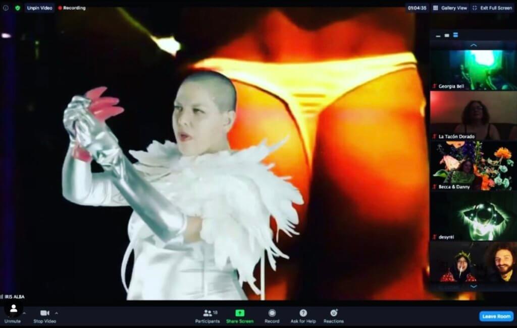Carmina Escobar eats a pink jelly bloody heart in a Zoom room. The background is a beautiful ass in a thong.